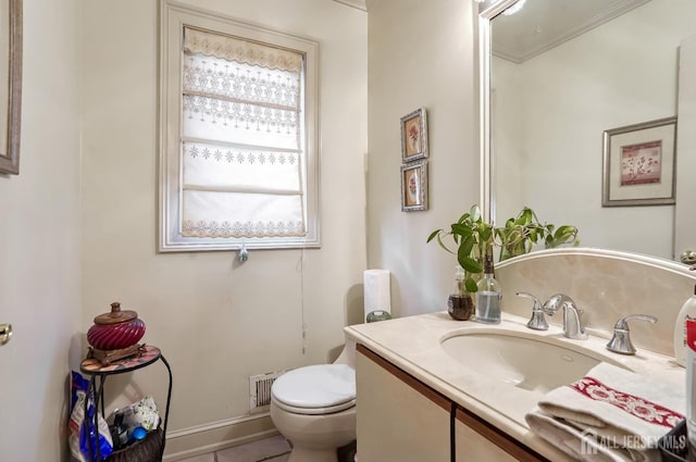 bathroom featuring vanity, ornamental molding, and toilet