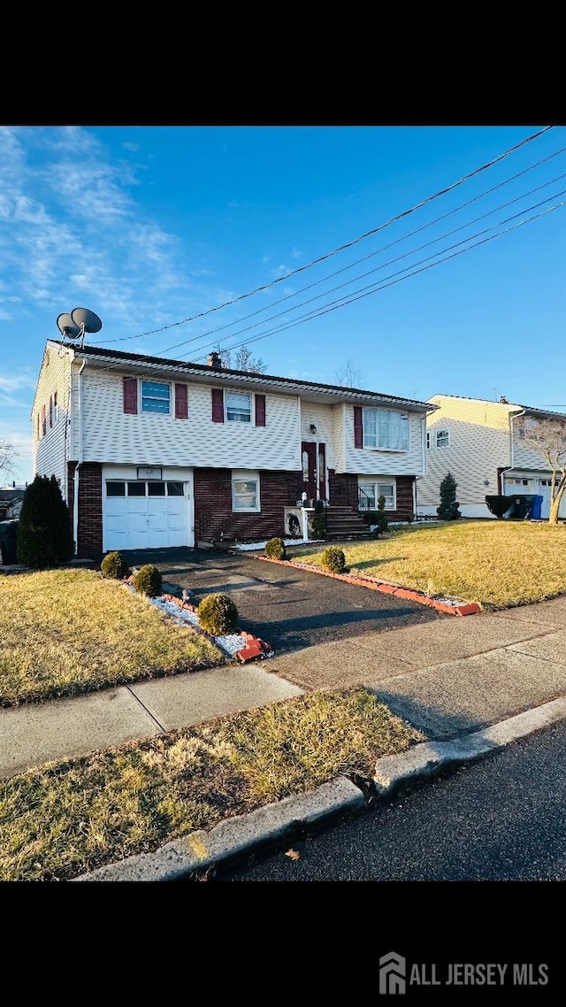 view of front of house featuring a garage and a front lawn