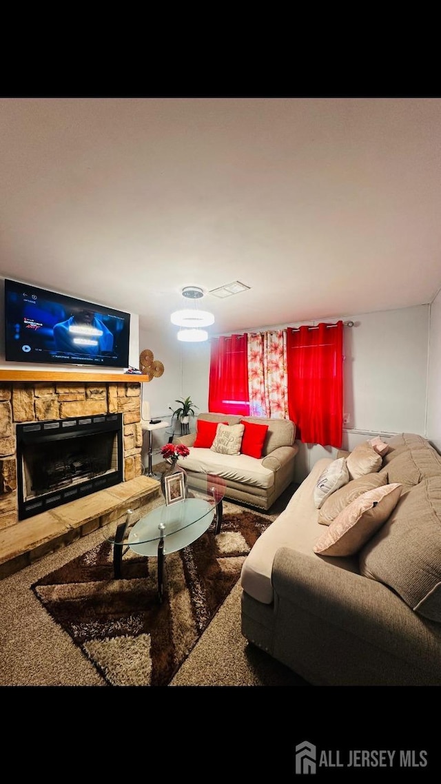 living room featuring a stone fireplace