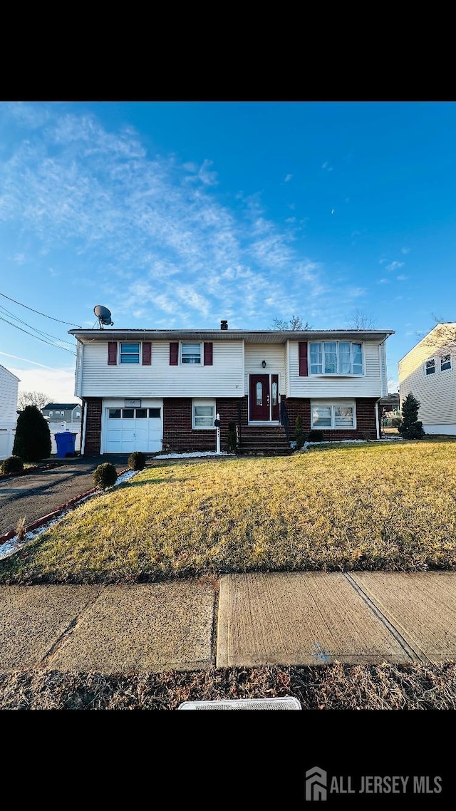 split foyer home with a garage and a front yard