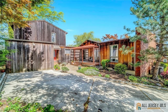 back of property with a wooden deck and a patio area