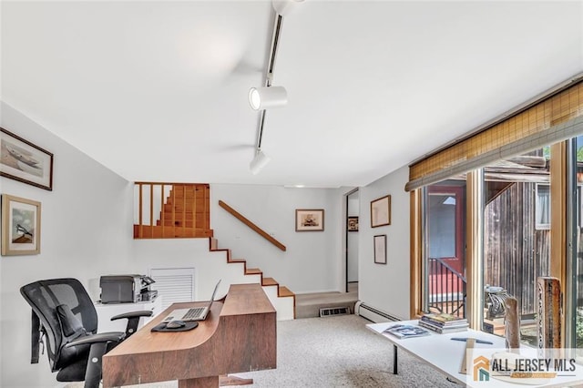 carpeted home office featuring a baseboard heating unit, visible vents, and track lighting