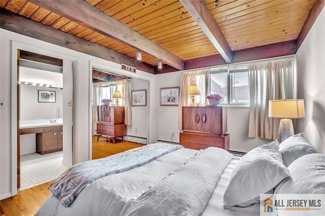 bedroom featuring wood finished floors, beamed ceiling, connected bathroom, a baseboard heating unit, and wooden ceiling