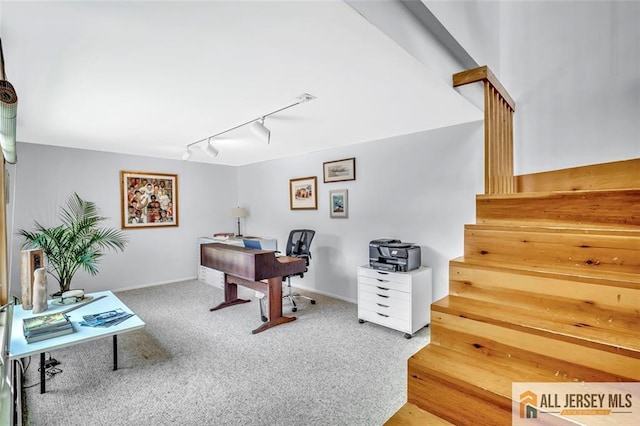carpeted home office featuring baseboards and rail lighting