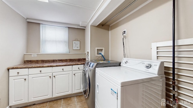 laundry area with cabinets, washer and clothes dryer, and light tile patterned floors