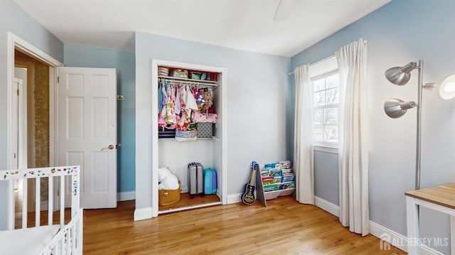 bedroom with light wood-type flooring, a closet, and ceiling fan