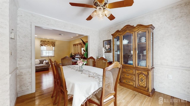 dining space featuring light wood-type flooring, crown molding, and ceiling fan