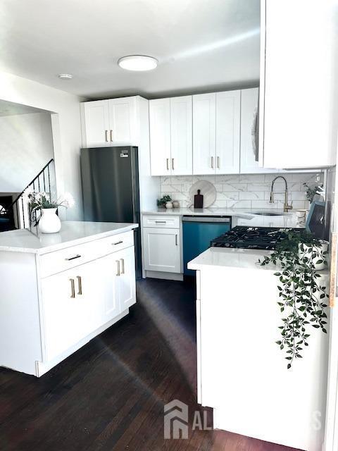 kitchen with white cabinets, dishwasher, tasteful backsplash, sink, and dark hardwood / wood-style floors