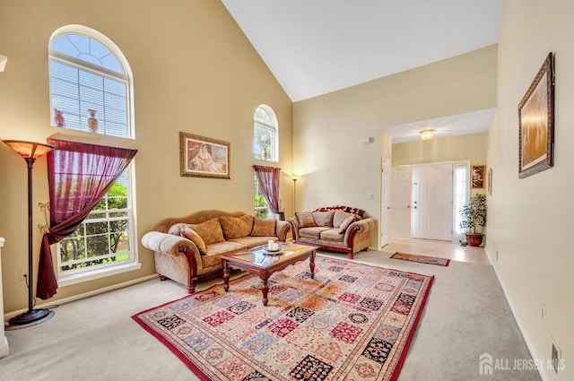 living room with carpet flooring, high vaulted ceiling, and baseboards