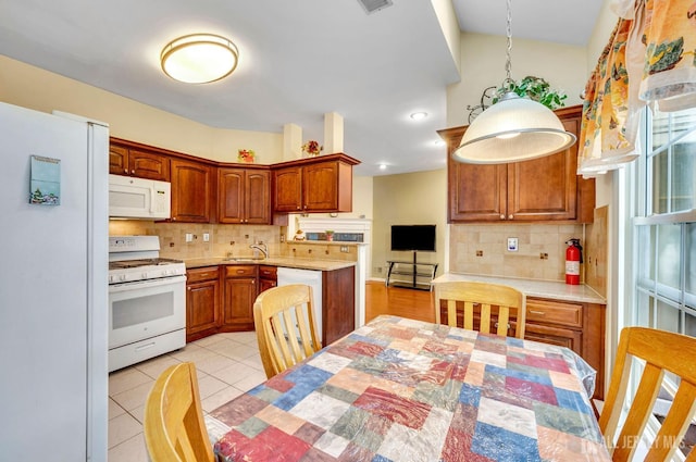 kitchen with white appliances, backsplash, and light countertops