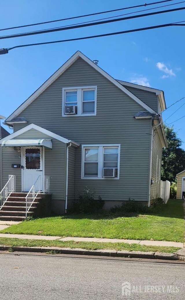 view of front facade featuring a front yard and cooling unit