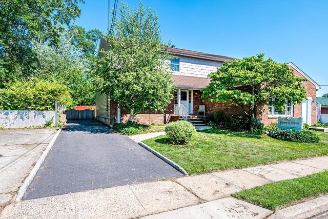 obstructed view of property featuring a front lawn