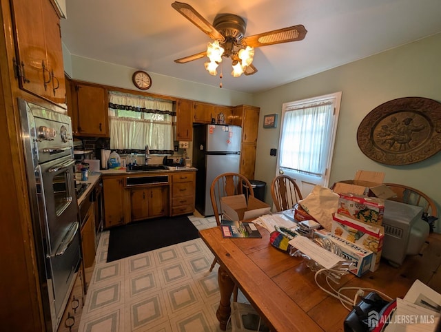 28 Tanglewood Ln, East Brunswick, NJ 08816 - kitchen featuring freestanding refrigerator, brown cabinetry, ceiling fan, a sink, and a warming drawer