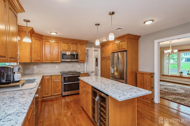 27 Briarwood Dr, Old Bridge, NJ 07747 - kitchen featuring stainless steel appliances, wine cooler, a baseboard heating unit, wood finished floors, and light stone counters