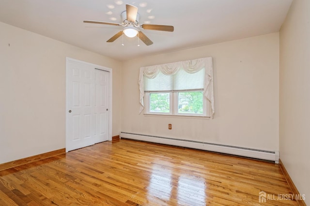 27 Briarwood Dr, Old Bridge, NJ 07747 - unfurnished bedroom with a baseboard heating unit, wood finished floors, baseboards, and ceiling fan