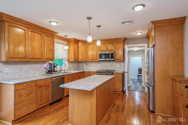 27 Briarwood Dr, Old Bridge, NJ 07747 - kitchen with appliances with stainless steel finishes, a sink, light wood finished floors, and brown cabinets