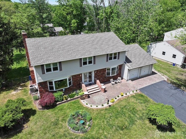 27 Briarwood Dr, Old Bridge, NJ 07747 - colonial home featuring a garage, asphalt driveway, a chimney, central AC unit, and roof with shingles