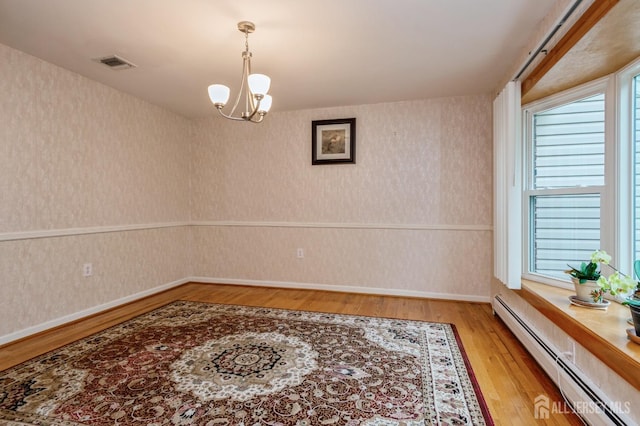 27 Briarwood Dr, Old Bridge, NJ 07747 - spare room with baseboard heating, a chandelier, baseboards, light wood-style flooring, and wallpapered walls
