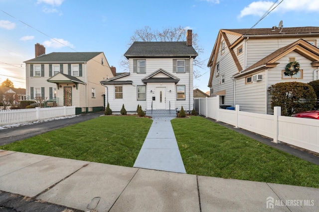 view of front of property featuring a front lawn, a chimney, and fence private yard