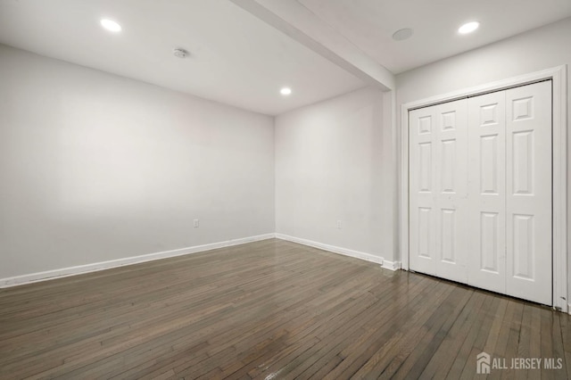 interior space with dark wood-type flooring, a closet, recessed lighting, and baseboards