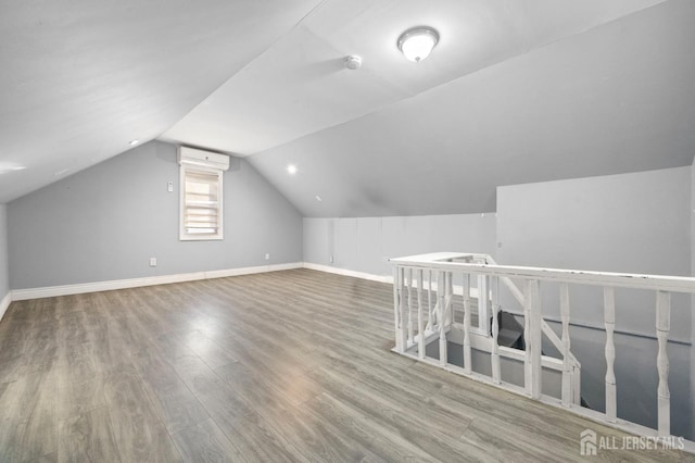 additional living space featuring baseboards, vaulted ceiling, and wood finished floors