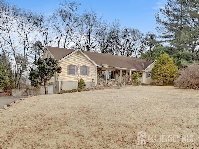 ranch-style home with driveway and a chimney