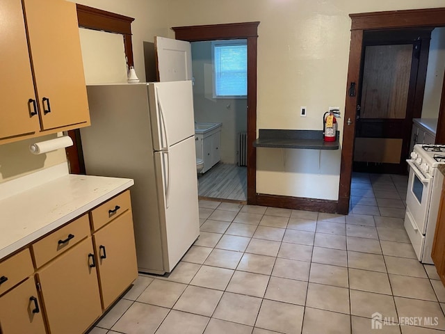 kitchen with white appliances, radiator heating unit, and light tile patterned floors