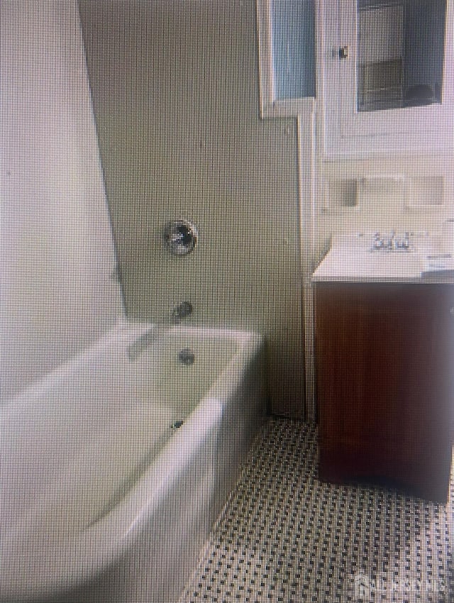 bathroom featuring tile patterned flooring, vanity, and shower / bathing tub combination