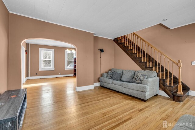 living room with light hardwood / wood-style flooring and ornamental molding