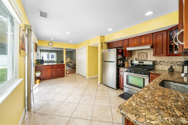 23 Boxwood Cir, Edison, NJ 08820 - kitchen with appliances with stainless steel finishes, under cabinet range hood, tasteful backsplash, light tile patterned floors, and glass insert cabinets
