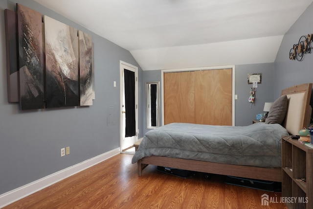 bedroom featuring a closet, wood-type flooring, and vaulted ceiling