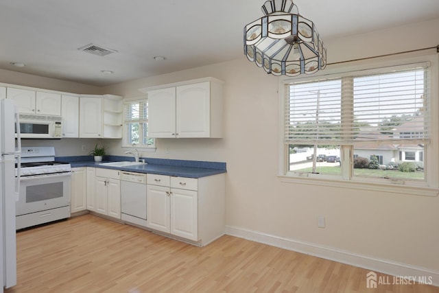 kitchen featuring white cabinets, white appliances, light hardwood / wood-style flooring, and sink