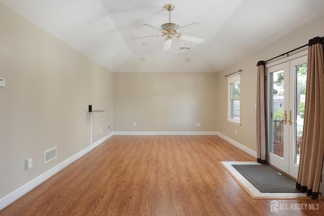 unfurnished room with ceiling fan, light wood-type flooring, french doors, and vaulted ceiling