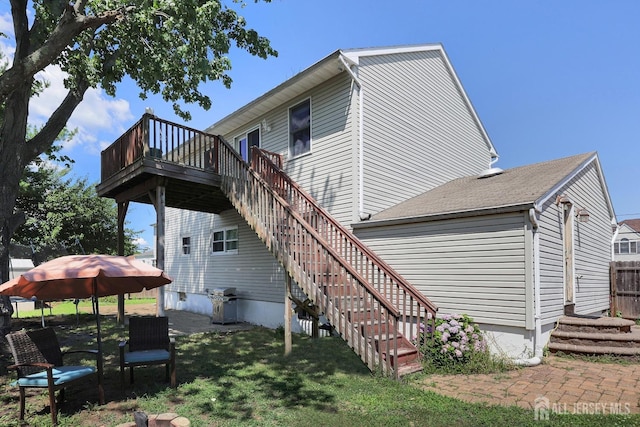 back of property with a gazebo, a deck, and a lawn