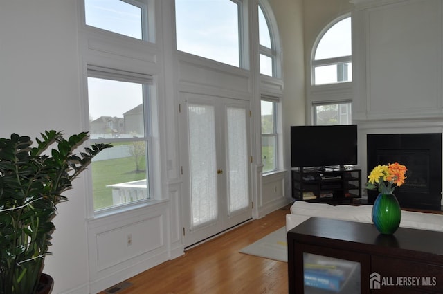 12 Sunny Ct, Monroe, NJ 08831 - living room with french doors, a large fireplace, light wood-style floors, and a high ceiling