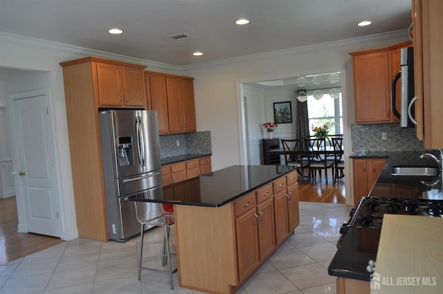 12 Sunny Ct, Monroe, NJ 08831 - kitchen featuring appliances with stainless steel finishes, a sink, a kitchen island, decorative backsplash, and light tile patterned flooring