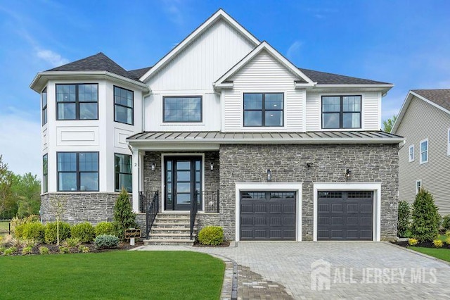 14 Bell Ave, Old Bridge, NJ 08857 - view of front of property with stone siding, a standing seam roof, an attached garage, a front yard, and decorative driveway