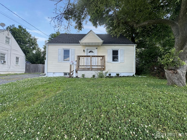 view of front of home with a deck and a front lawn