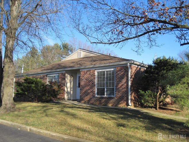 view of front of home with a front yard and brick siding