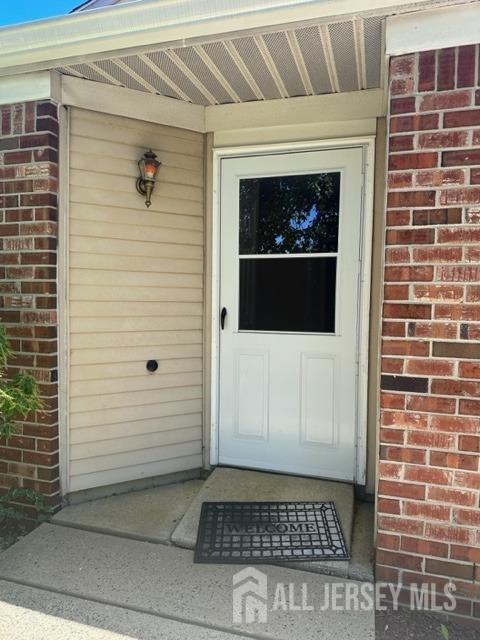 doorway to property with brick siding