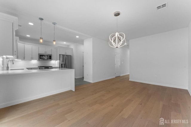 243 E 9th Ave, Roselle, NJ 07203 - kitchen featuring stainless steel appliances, a chandelier, light wood-type flooring, recessed lighting, and light countertops