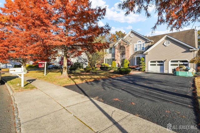 view of front facade featuring a garage, driveway, and a front lawn