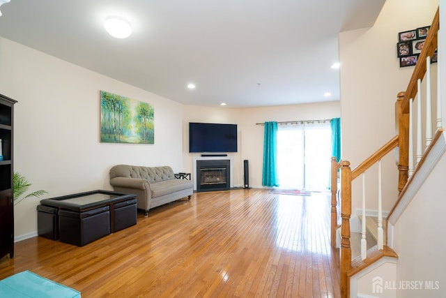 908 Blossom Cir S, Brunswick, NJ 08810 - living room featuring stairway, light wood-style floors, a glass covered fireplace, and recessed lighting
