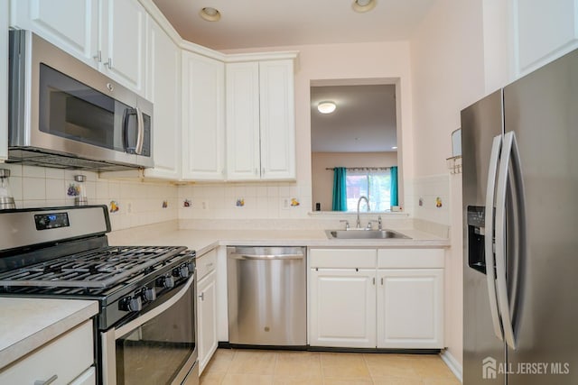 908 Blossom Cir S, Brunswick, NJ 08810 - kitchen featuring appliances with stainless steel finishes, light countertops, tasteful backsplash, white cabinets, and light tile patterned floors