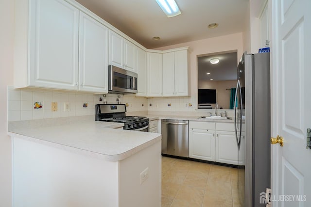 908 Blossom Cir S, Brunswick, NJ 08810 - kitchen featuring appliances with stainless steel finishes, a peninsula, tasteful backsplash, white cabinets, and light countertops