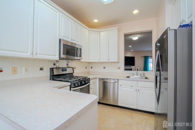 908 Blossom Cir S, Brunswick, NJ 08810 - kitchen featuring stainless steel appliances, backsplash, white cabinetry, light countertops, and a peninsula