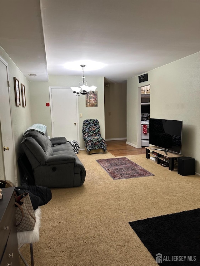 carpeted living room with a notable chandelier