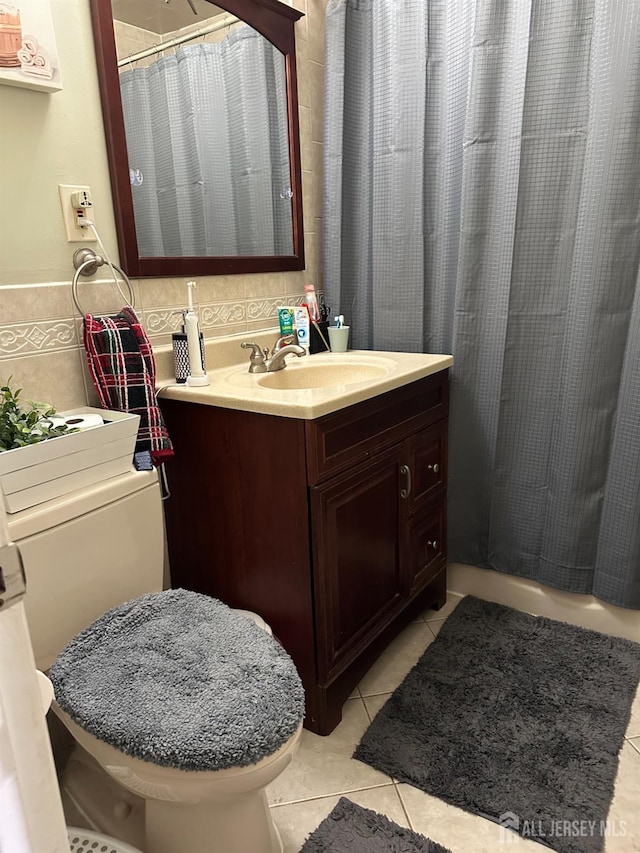 bathroom with tile walls, tile patterned flooring, and vanity