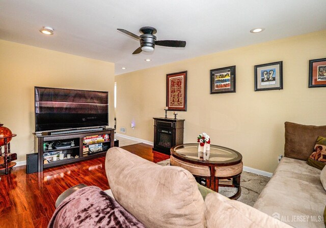 living room with wood-type flooring, a fireplace, and ceiling fan