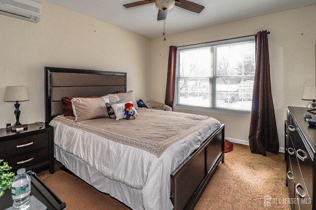 carpeted bedroom with a wall unit AC and ceiling fan